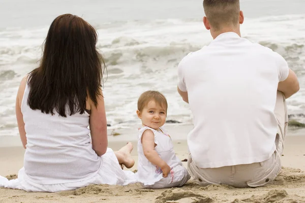 Familia joven divirtiéndose al aire libre en la playa . —  Fotos de Stock