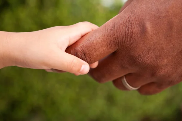 Padre e hijo tomados de la mano. Familia multicultural . —  Fotos de Stock