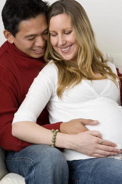 Husband embraceing his pregnant wifes belly. — Stock Photo, Image