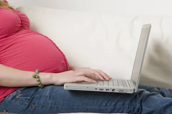Schwangere tippt am Computer. — Stockfoto