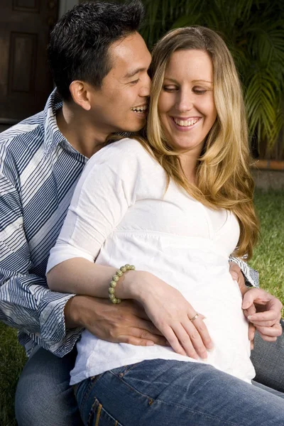Esposo abrazando a sus esposas embarazadas vientre . —  Fotos de Stock