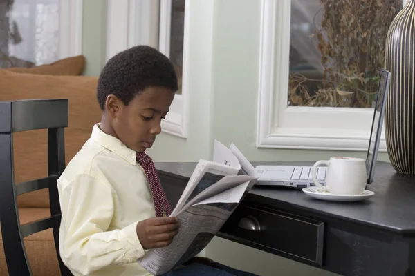 Menino lendo o jornal em casa . — Fotografia de Stock