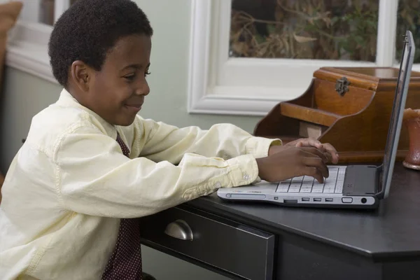 Menino trabalhando no computador em casa . — Fotografia de Stock