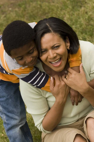 Kleine jongen die zijn moeder buiten knuffelen. — Stockfoto