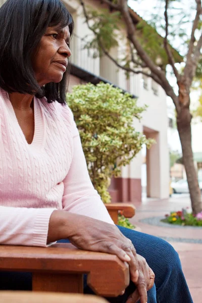 ベンチに座っている年配のアフリカ系アメリカ人の女性. — ストック写真
