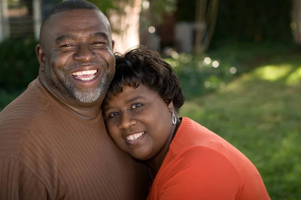 Äldre afrikanska amerikanska par skrattar och kramar. — Stockfoto
