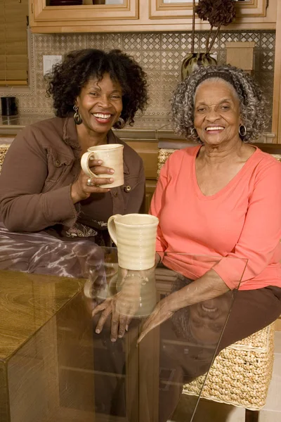 Ανώτερος γυναίκα πίνοντας καφέ με την κόρη της. — Φωτογραφία Αρχείου