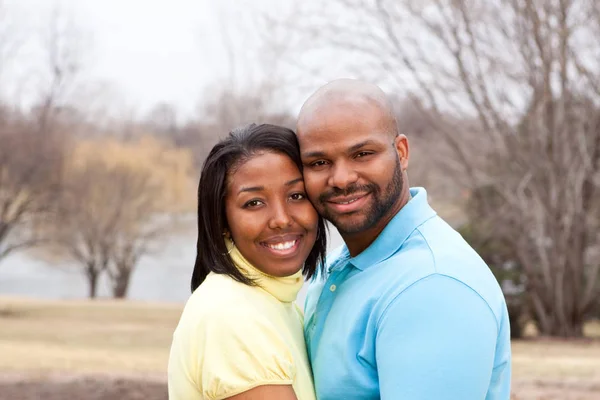 Kärleksfull lyckliga African American paret kramas och ler. — Stockfoto