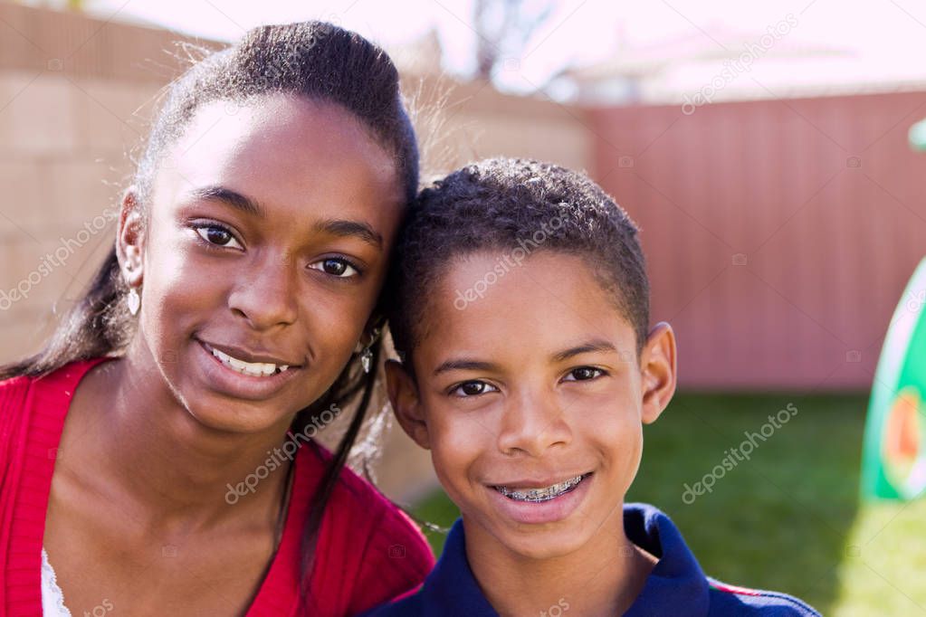 Happy African American brother and sister smiling.