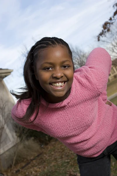 Gelukkig African American jong meisje glimlachend buiten. — Stockfoto