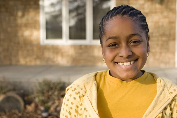 Gelukkig African American jong meisje glimlachend buiten. — Stockfoto