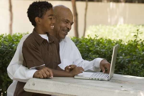 Avô e neto afro-americanos trabalhando no computador . — Fotografia de Stock