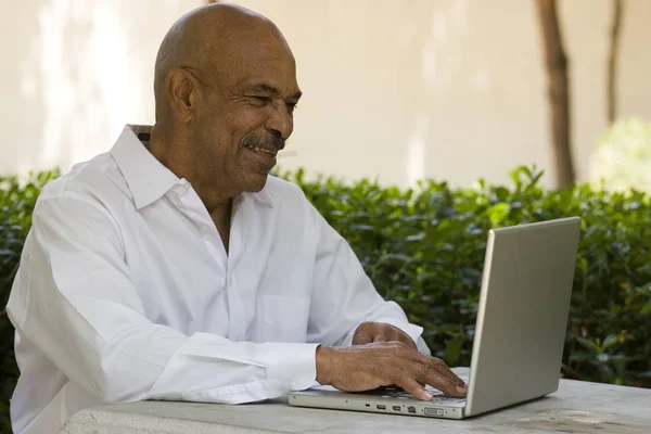 African American senior citizen working on laptop computer — Stock Photo, Image