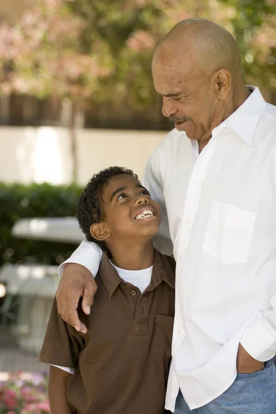 Happy African American grandfather and grandson laughing.