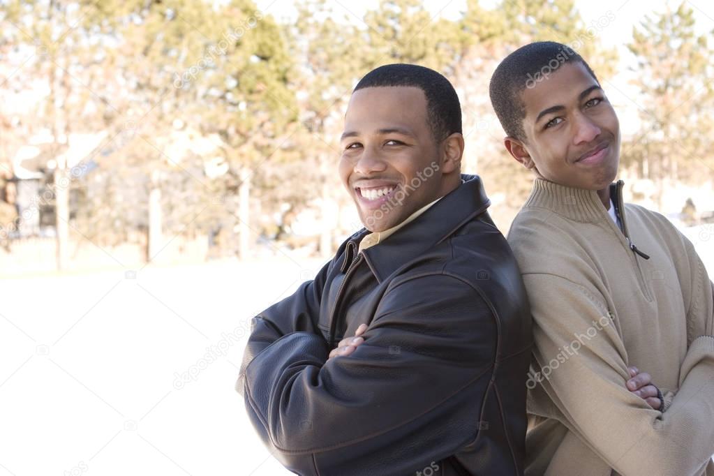Portrait of African American teenage brothers smiling.