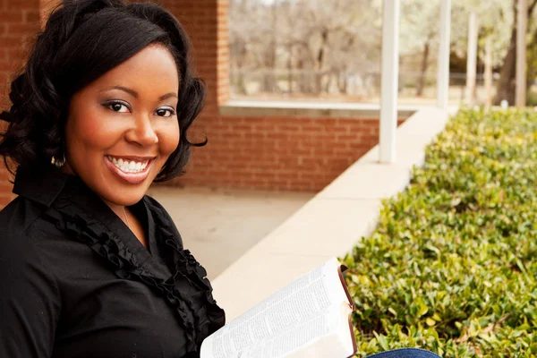 African American woman sitting outside reading. — Stock Photo, Image