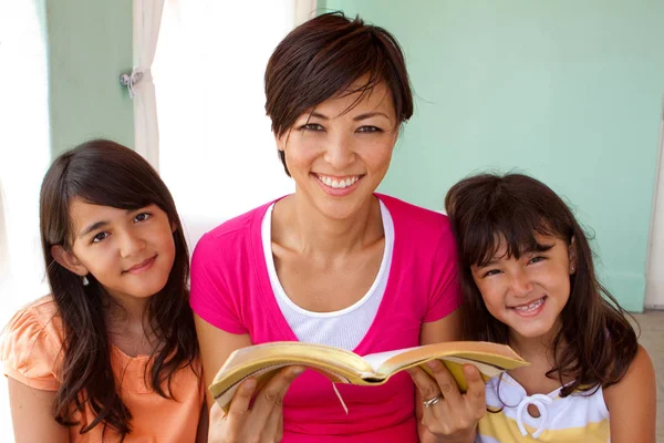 Mor spendera tid med att läsa med döttrarna. — Stockfoto