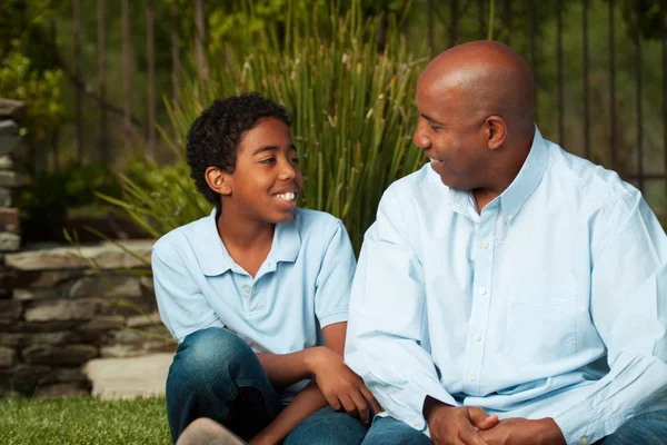 Afro-Amerikaanse vader en zoon praten en lachen. — Stockfoto