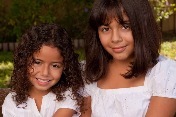 Hispanische Schwestern lachen und lächeln draußen. — Stockfoto