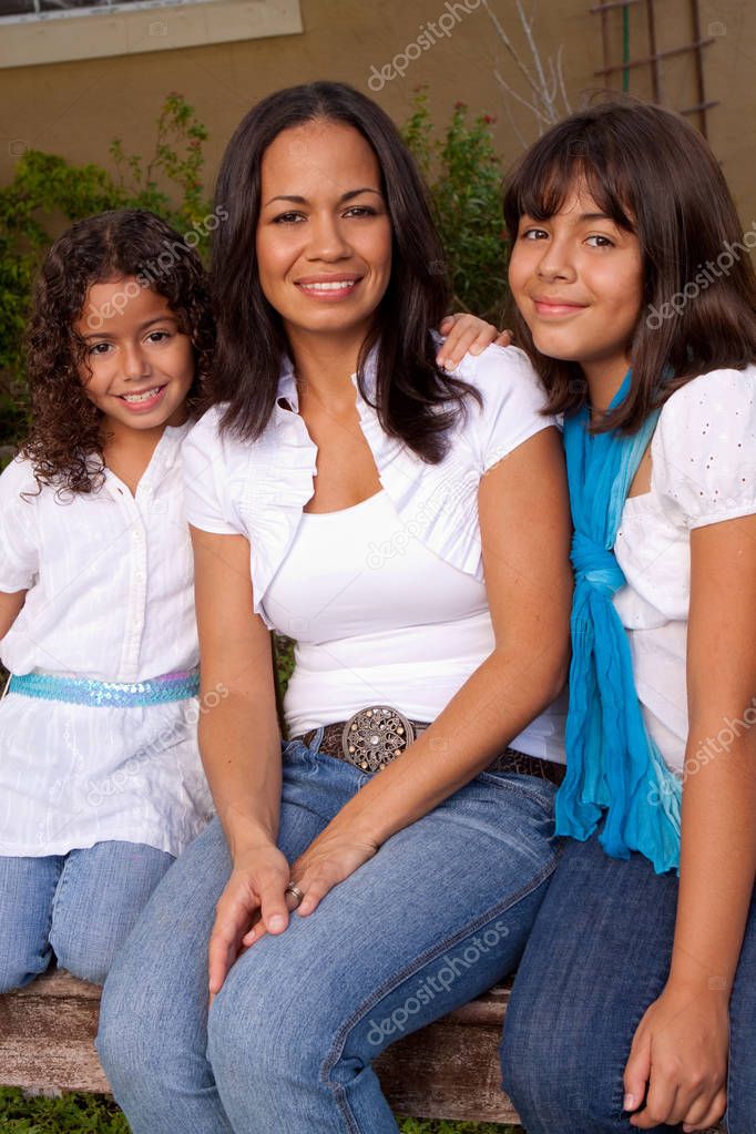 Happy Hispanic mother and daughters smiling.