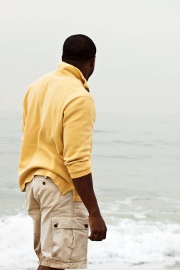 Afrika kökenli Amerikalı adam sahilde yürüyüş.