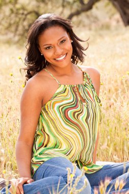 Bir alan gülümseyerek oturan mutlu kadın.