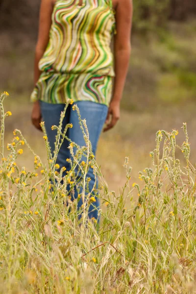 Mujer feliz sentada en un campo sonriendo . — Foto de Stock