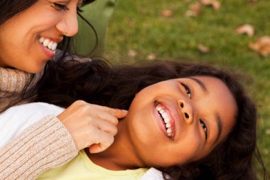 Biracial anne ve gülüyor ve dışarıda gülümseyen kız.