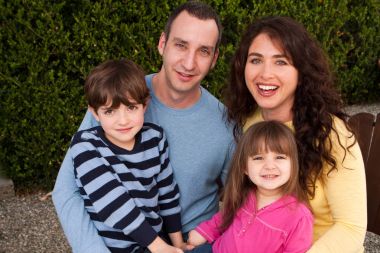 Gülümseyen ve gülerek mutlu bir aile portresi.