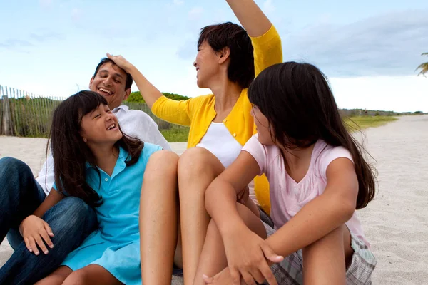 Aziatische familie lachen en spelen op het strand. — Stockfoto