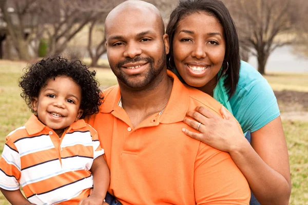 Família afro-americana feliz sorrindo lá fora . — Fotografia de Stock