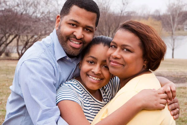 Gelukkige Afro-Amerikaanse familie glimlachend buiten — Stockfoto