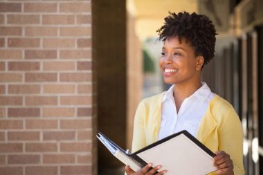 Bir defter tutan gülümseyen kadın.