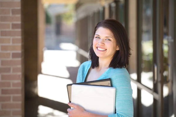 Mujer sonriendo sosteniendo un cuaderno . — Foto de Stock