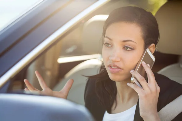 Affärskvinna talar på hennes mobiltelefon och körning. — Stockfoto