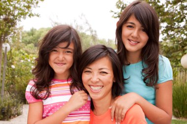 Sevgi dolu Asya anne ve kızı gülümseyen.