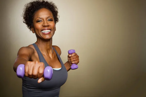 Femme afro-américaine levant des poids . — Photo