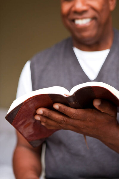 Close up of a man reading the Bible.