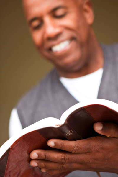 Close up of a man reading the Bible.
