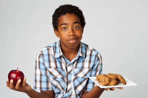 Niño tomando decisiones de comer versos saludables poco saludable . —  Fotos de Stock