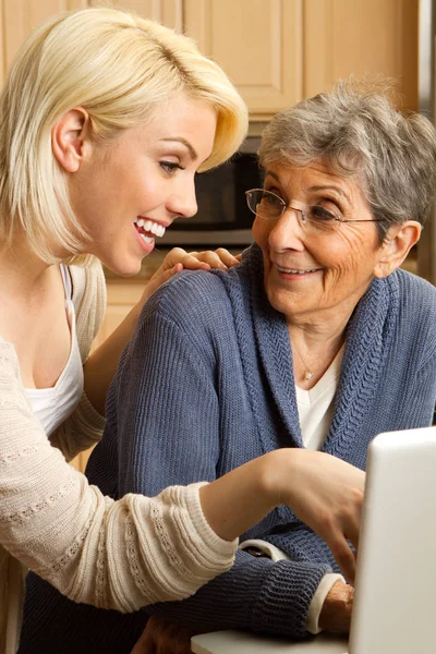 Kleindochter helpen haar grootmoeder op de computer. — Stockfoto