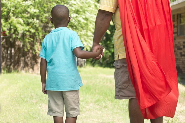 Маленький мальчик со своим отцом супергероем . — стоковое фото