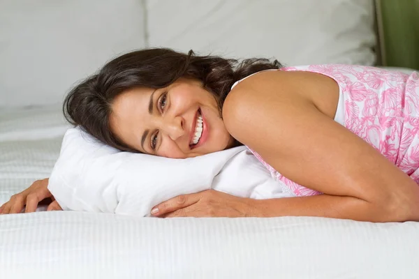 Mature hispanique femme couchée dans un lit . — Photo