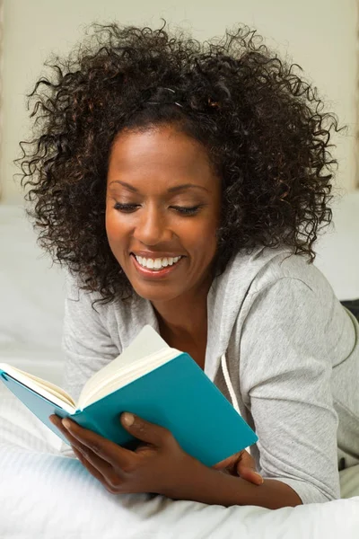 Beautiful mature woman smiling and reading. Stock Picture