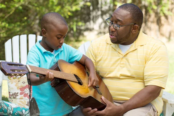 Padre teaaching suo figlio a suonare la chitarra . — Foto Stock
