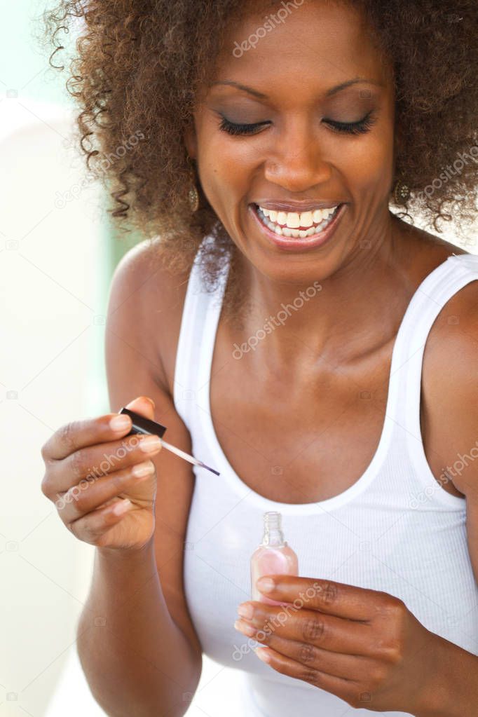 Beautiful mature woman applying nail polish.