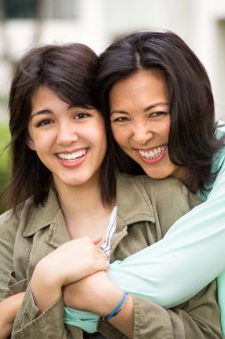 Asya gülen ve huging çocuğunu anne.