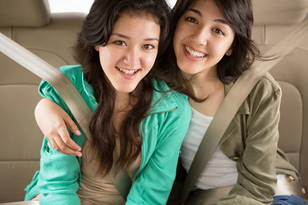 Jonge tiener meisjes glimlachen op de achterbank — Stockfoto
