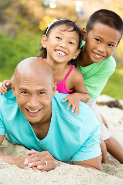 Père jouant avec ses enfants sur la plage . — Photo