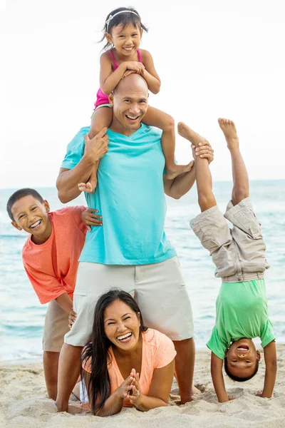 Boldog család játszik a strandon. — Stock Fotó